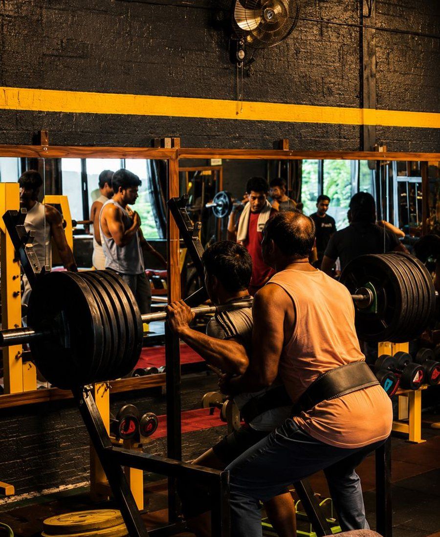A trainer coaching a member through a lift at Bulls Gym